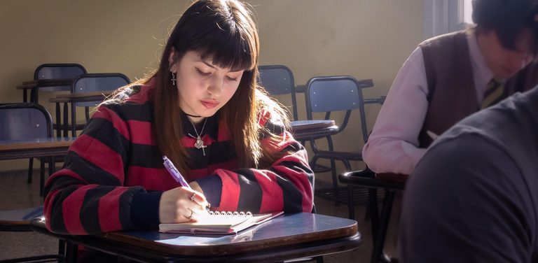 Estudiante escribiendo en un cuaderno